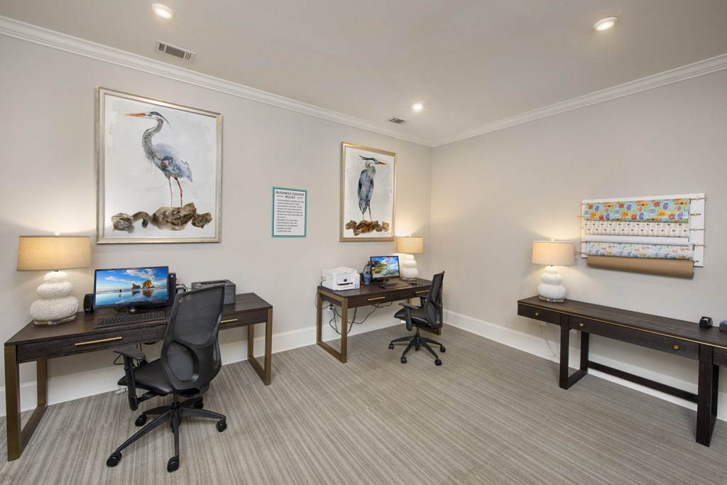 a room with two desks and two chairs and two paintings on the wall