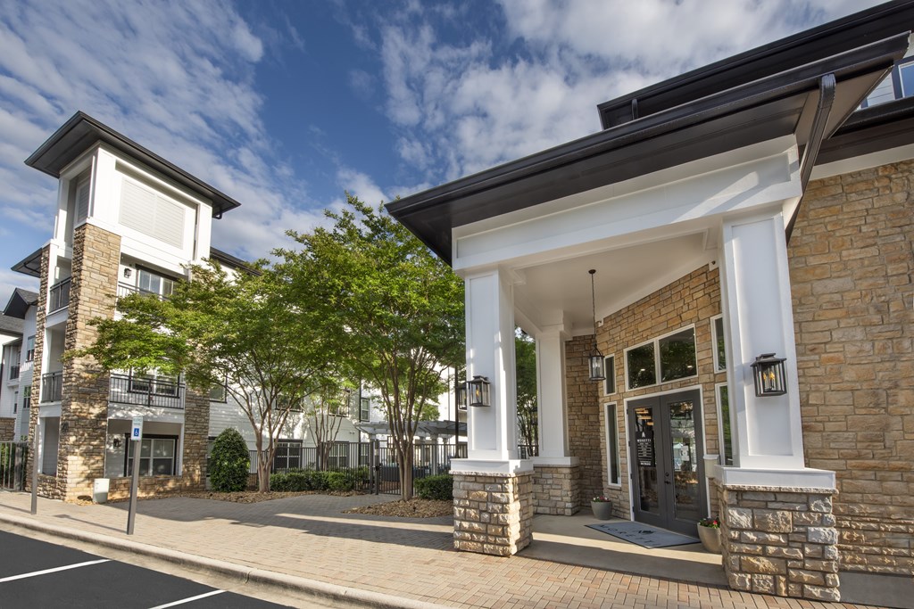 A modern building with a stone facade and a black door.