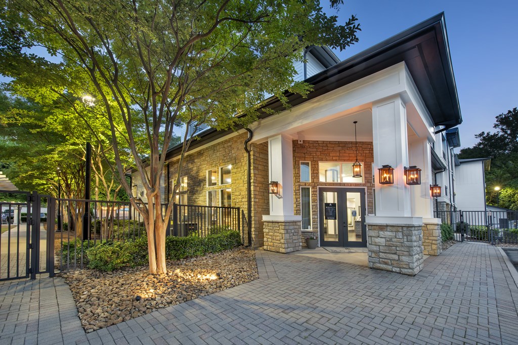 A house with a black fence and a tree in front.