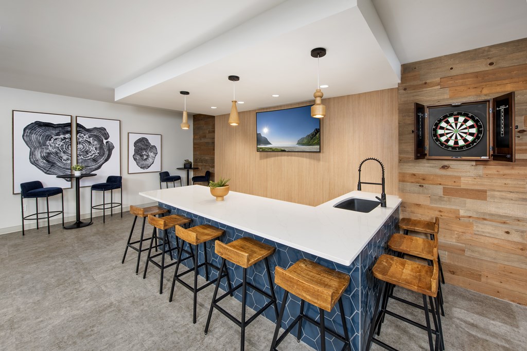 A modern bar area with a dart board on the wall.