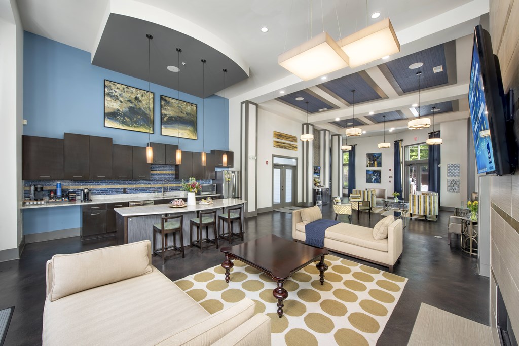 A modern living room with a kitchen area in the background.