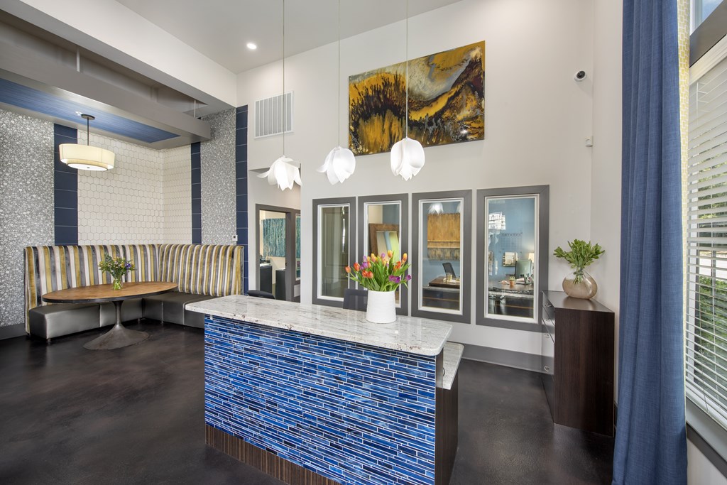 A reception area with a blue tile counter and a striped couch.