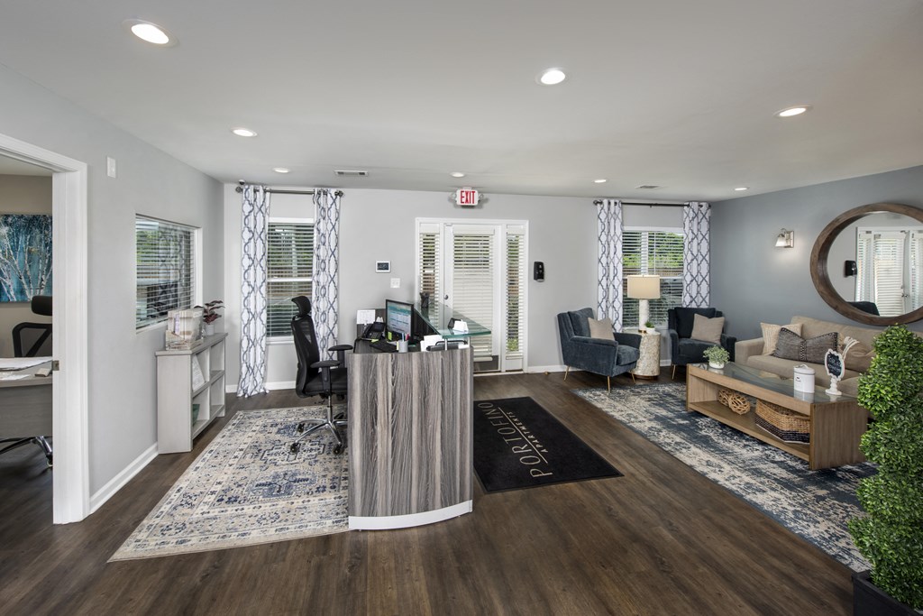 a living room with a desk and a couch and a rug