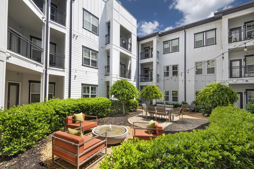 A white apartment building with a patio and a fire pit.
