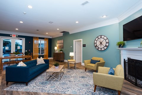 a living room with blue furniture and a clock on the wall