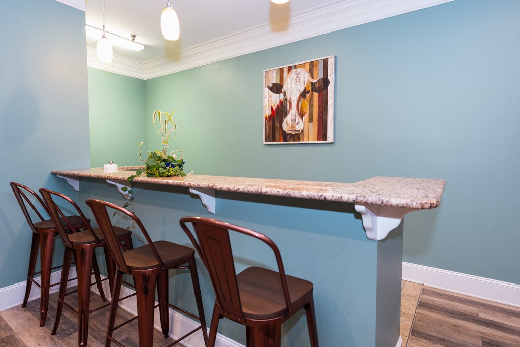a bar with four chairs and a counter with a marble counter top