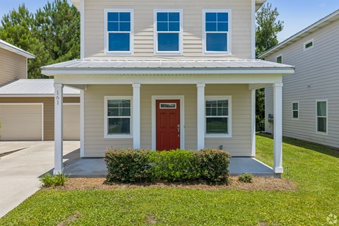 A house with a red door and a white porch.