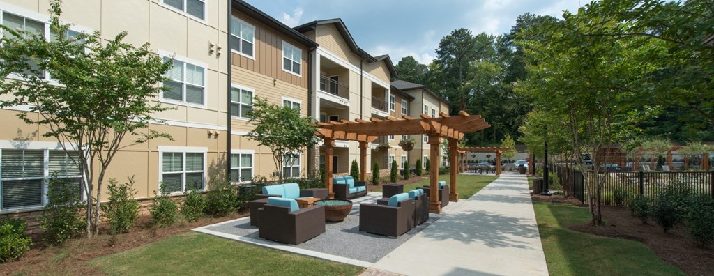 an outdoor patio area with furniture in front of an apartment building