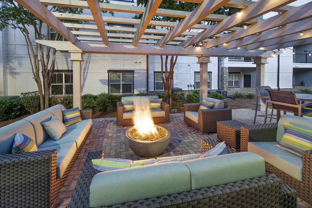 A patio with a fire pit and seating area.