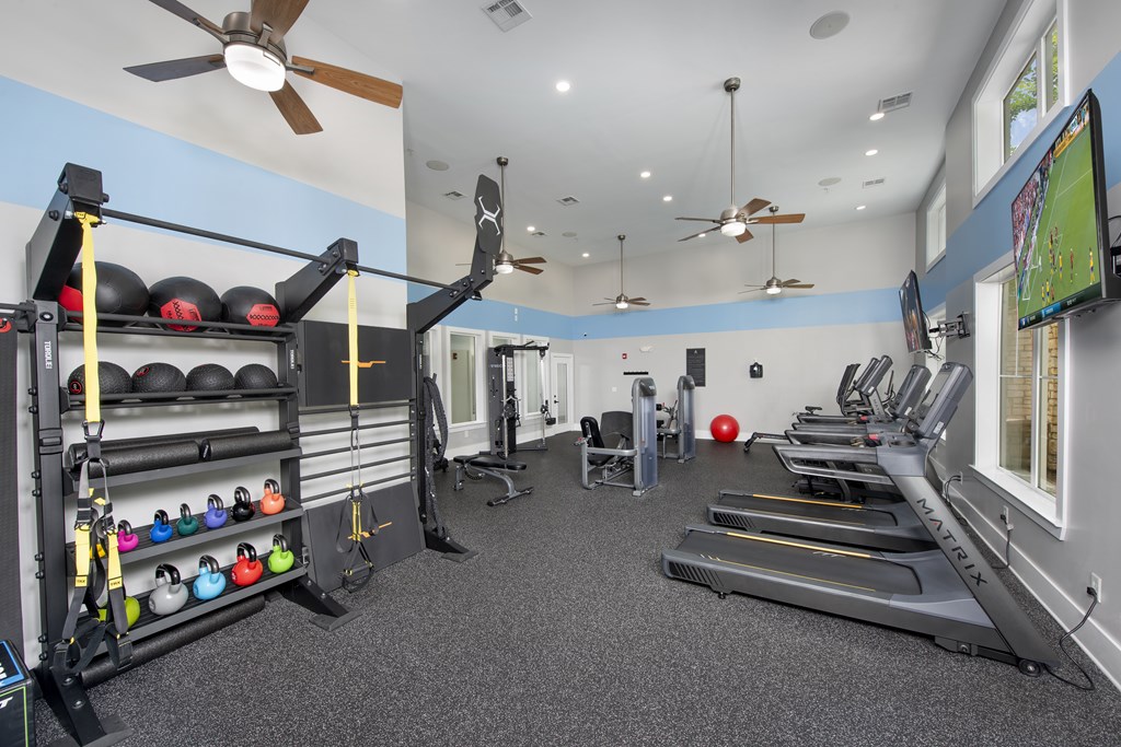 A gym with treadmills, weights, and exercise equipment.