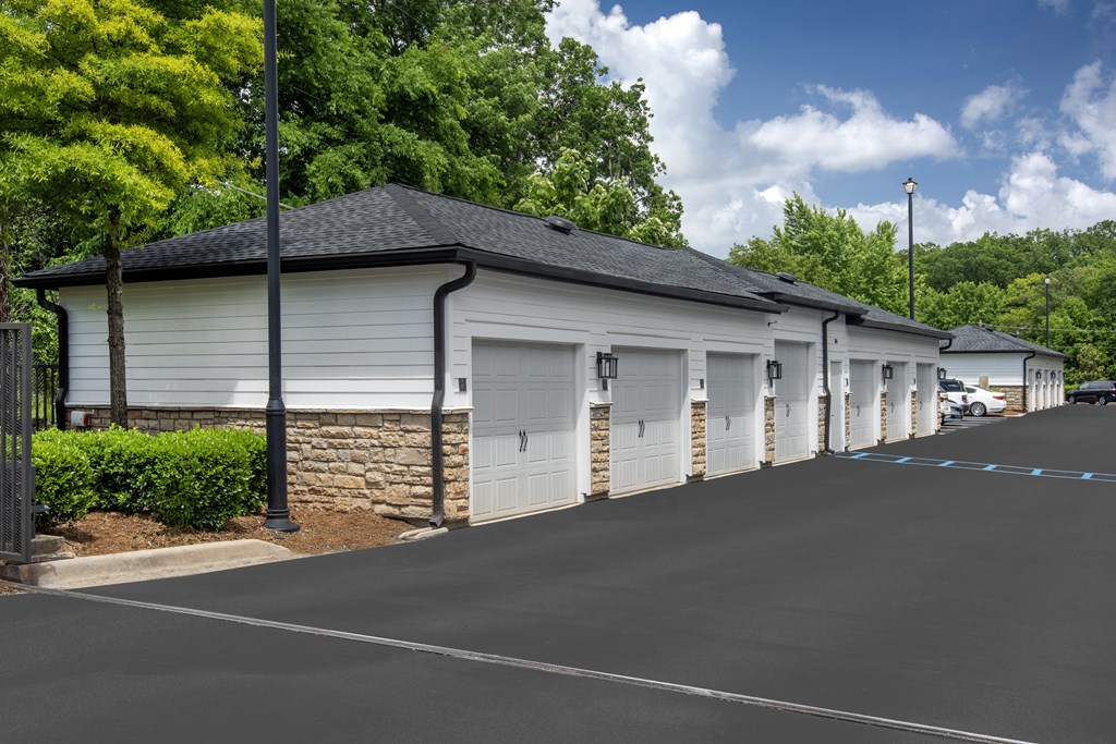 A long row of garages with trees in the background.