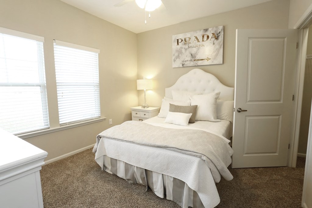 a bedroom with a bed and two windows