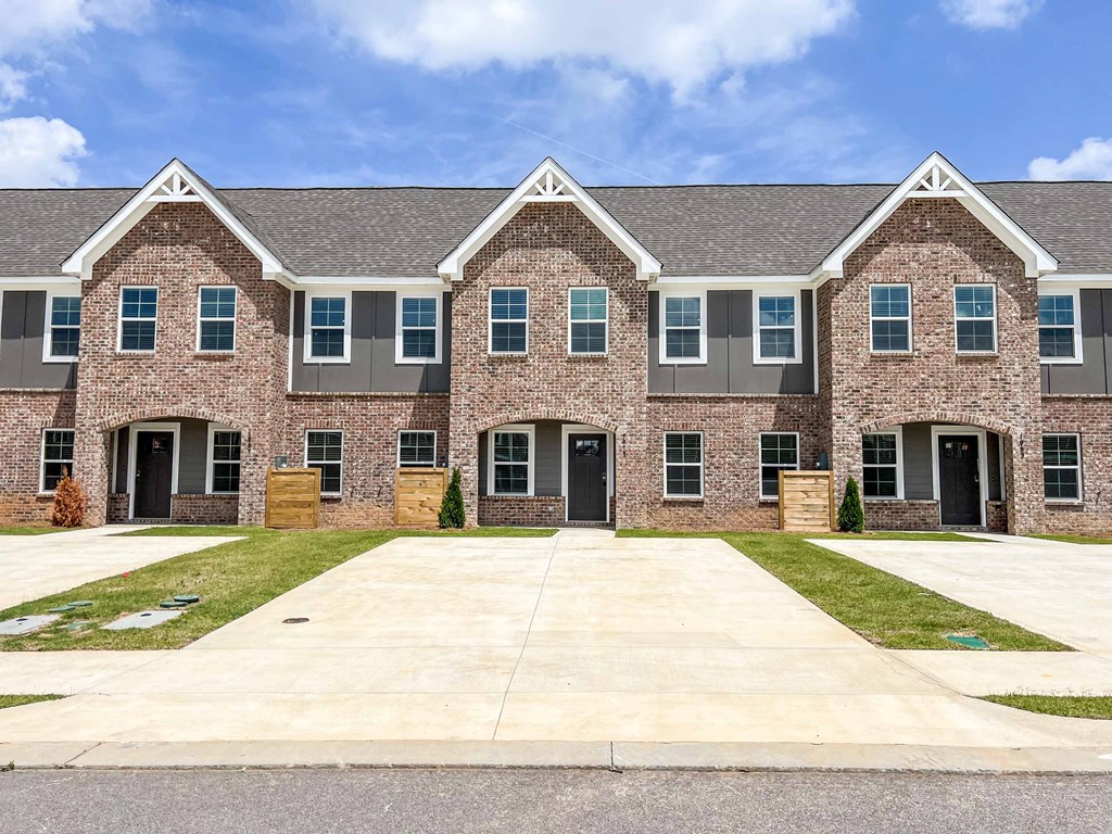 a large brick house with a yard and a driveway