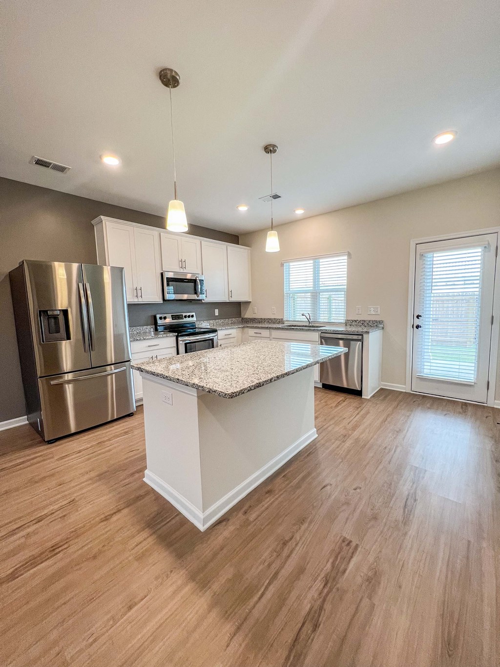 an open kitchen with an island and stainless steel appliances