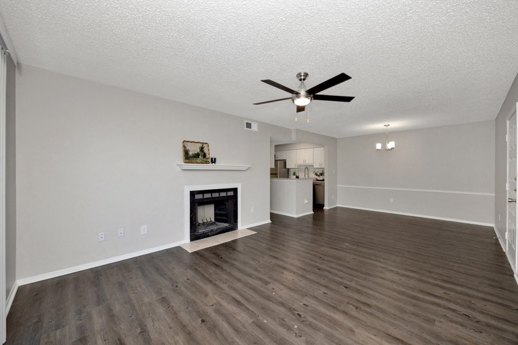 A living room with a fireplace and a ceiling fan.