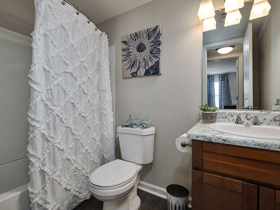 a bathroom with a shower curtain and a toilet and a sink