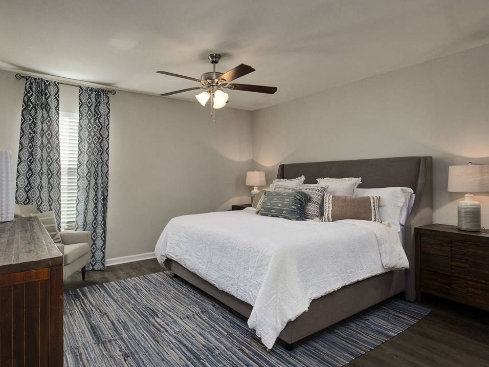 a bedroom with a bed and a ceiling fan