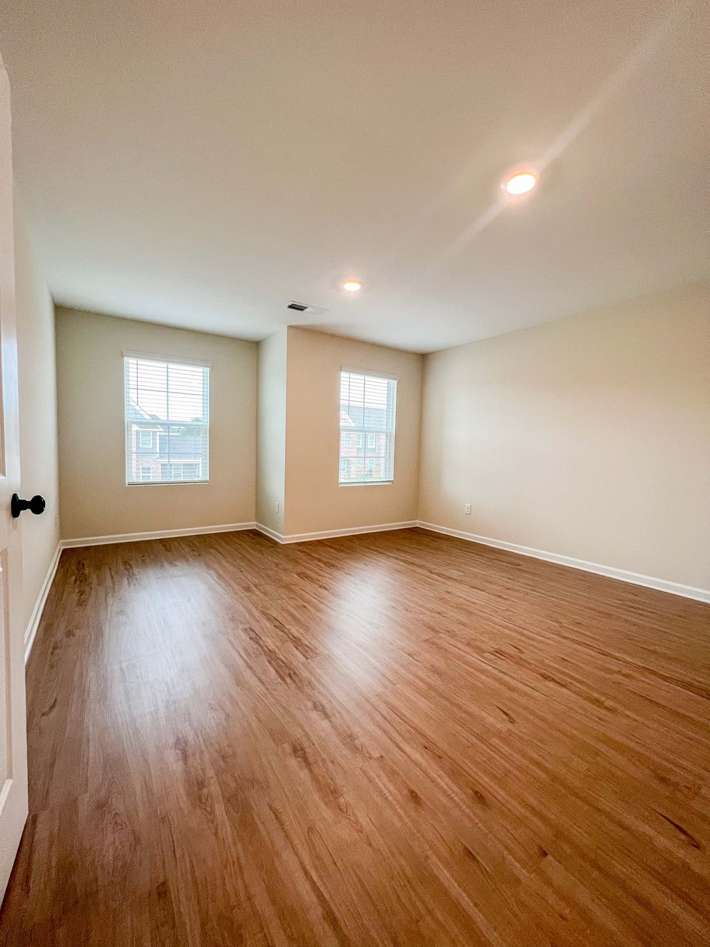 an empty living room with wood floors and white walls