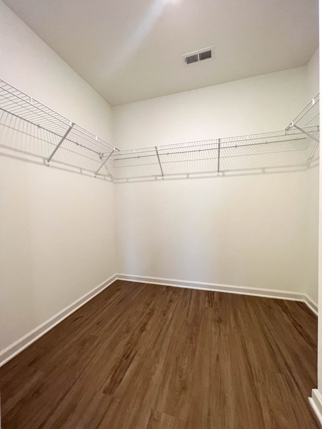 an empty bedroom with white walls and wood floors