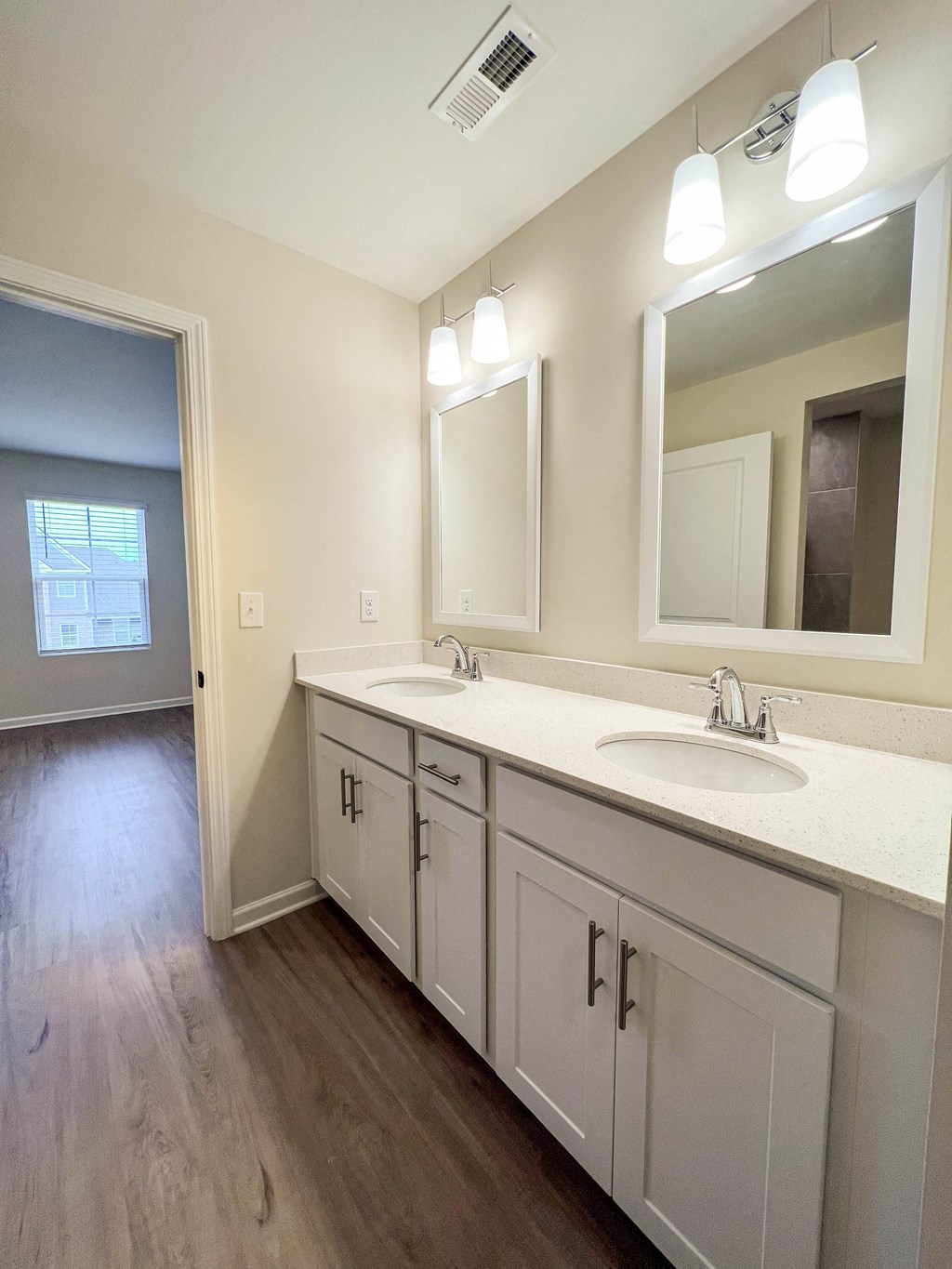an empty bathroom with two sinks and a mirror