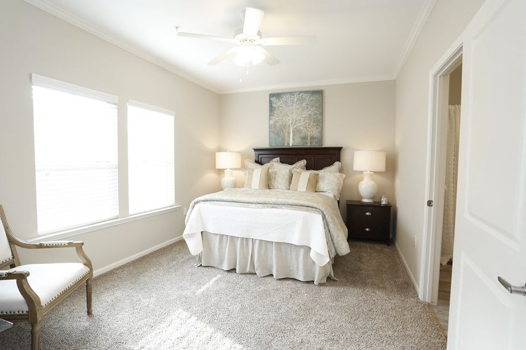 a bedroom with a large bed and a ceiling fan