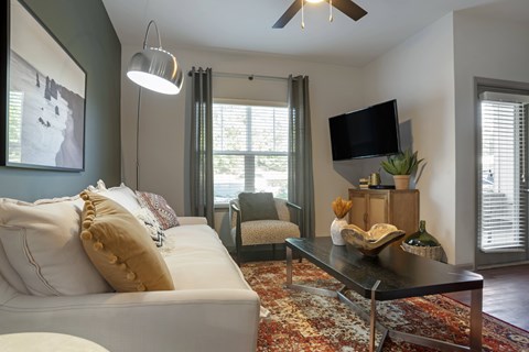 A living room with a white couch and a black coffee table.