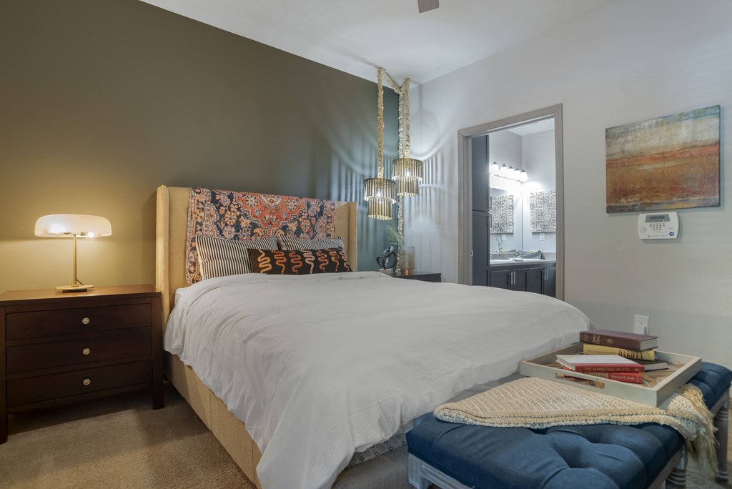A bedroom with a large bed and a chandelier.