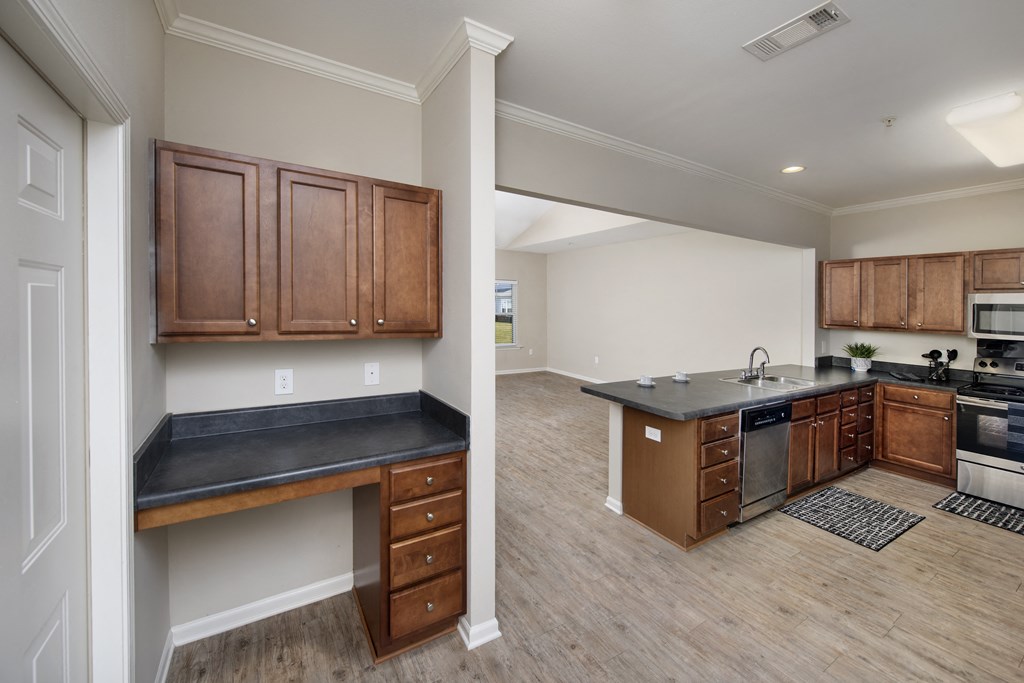 a kitchen and living room with wood floors and wooden cabinets