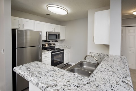 a kitchen with granite counter tops and stainless steel appliances