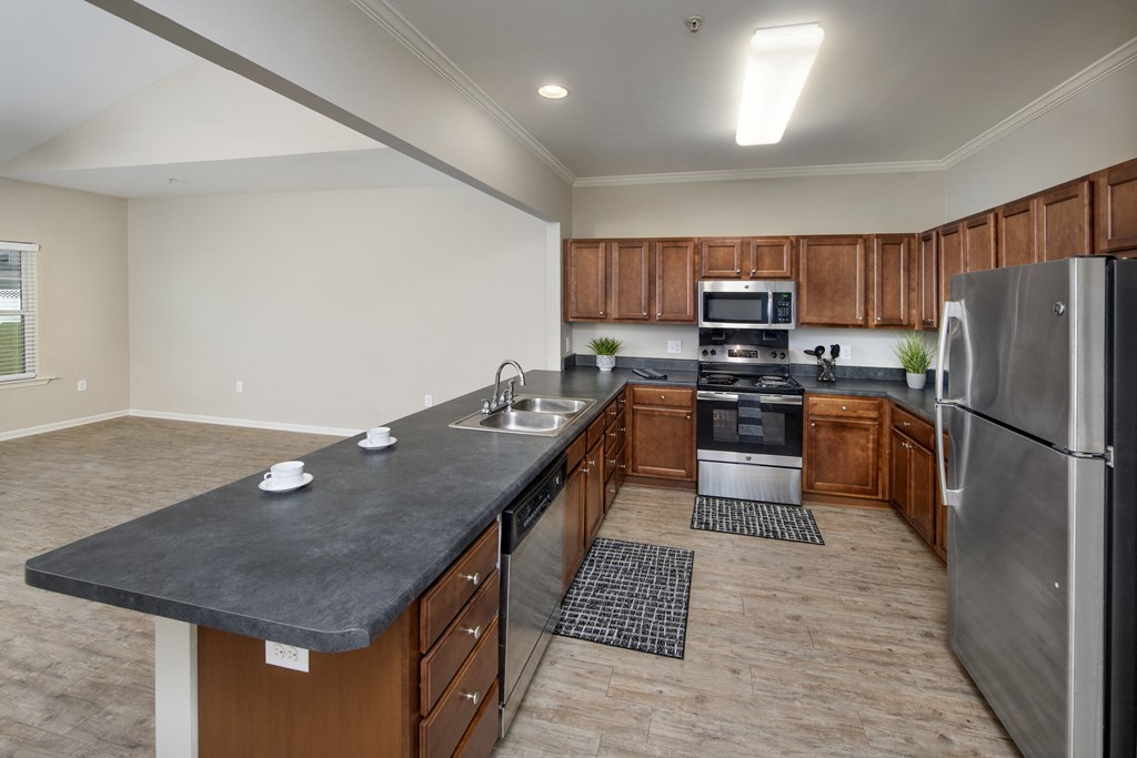 a large kitchen with stainless steel appliances and wood cabinets