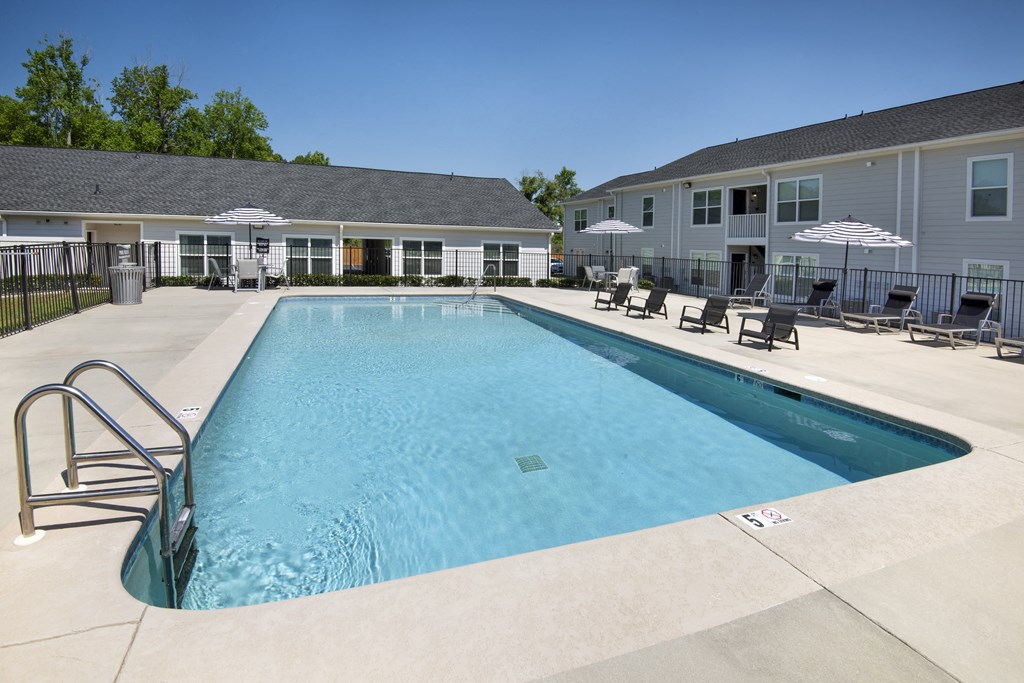 our apartments have a large swimming pool with chairs and umbrellas