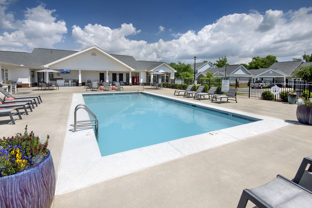 our resort style swimming pool is next to our building with lounge chairs and tables