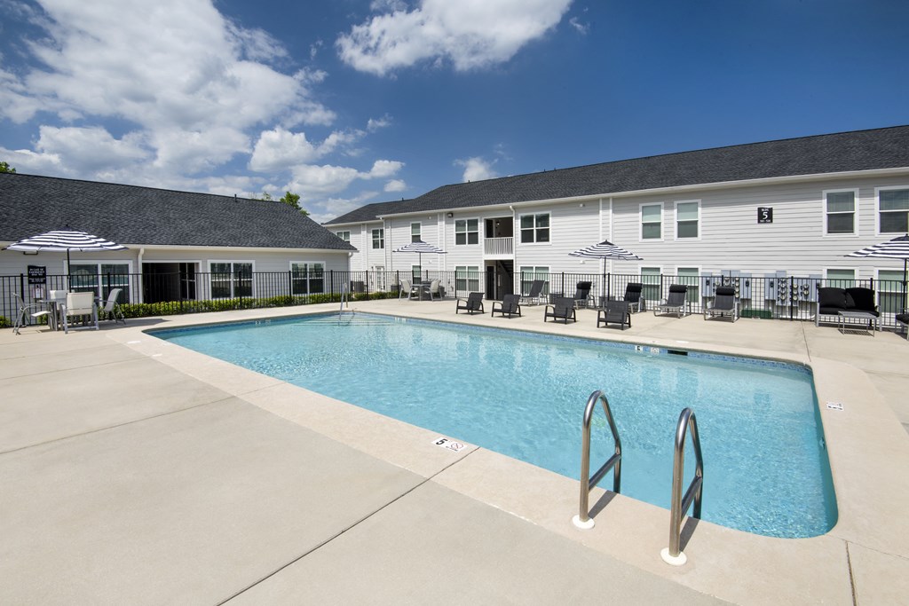 our apartments have a large swimming pool with chairs and umbrellas