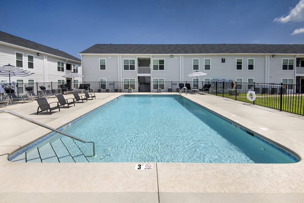 our apartments have a resort style pool with chairs and umbrellas
