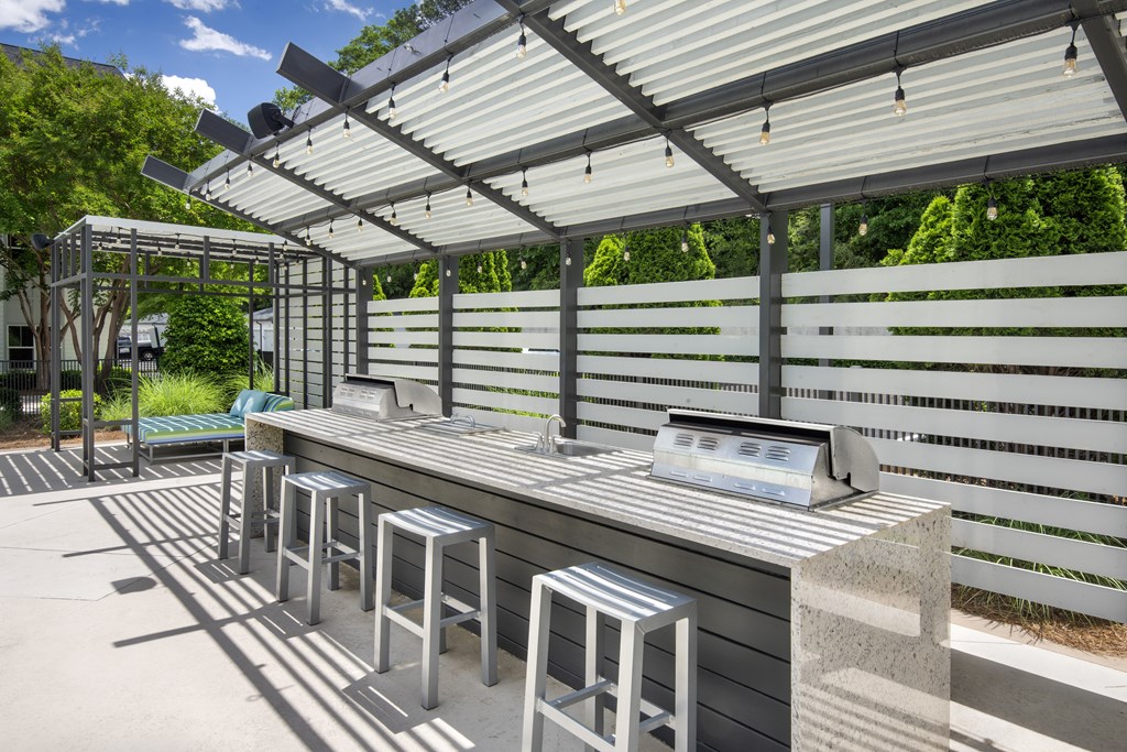 A row of stools are lined up under a roof.