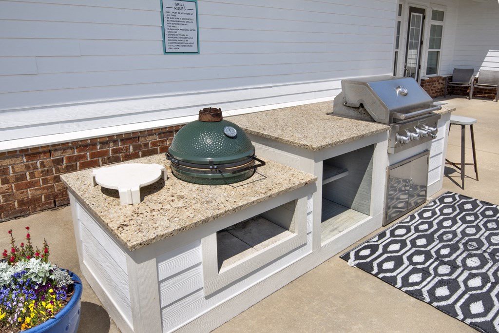 an outdoor kitchen with a grill and a counter with a pot on it