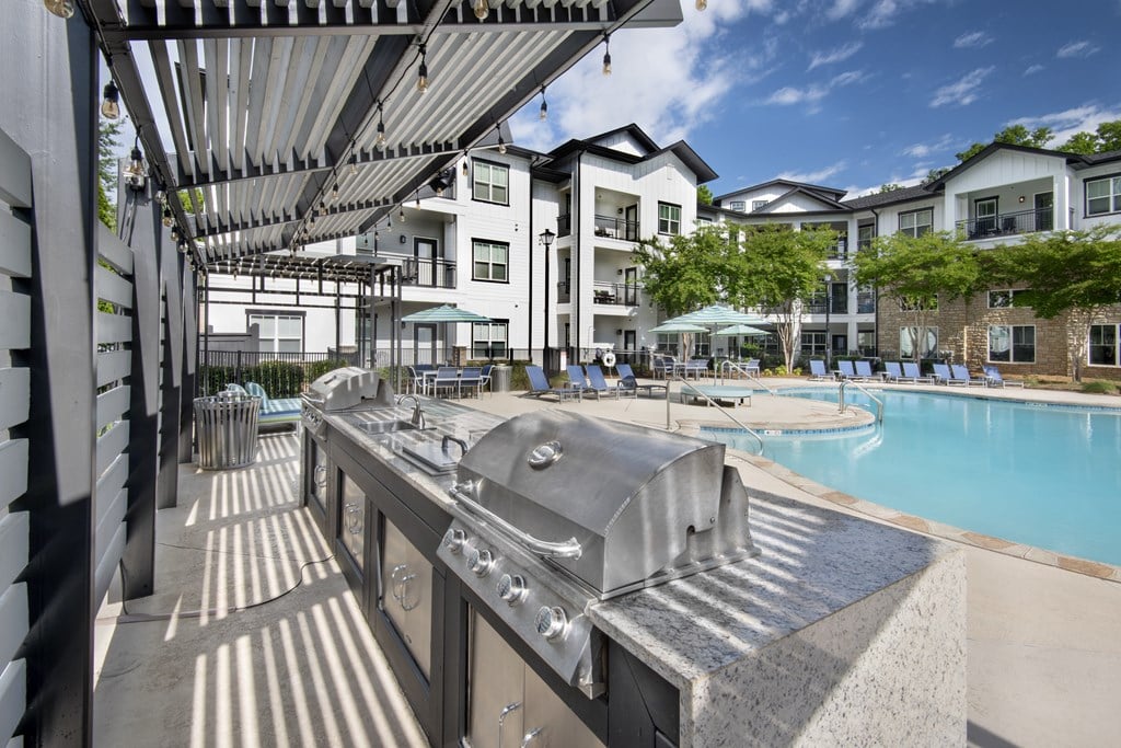 A large outdoor pool with a slide and a building in the background.