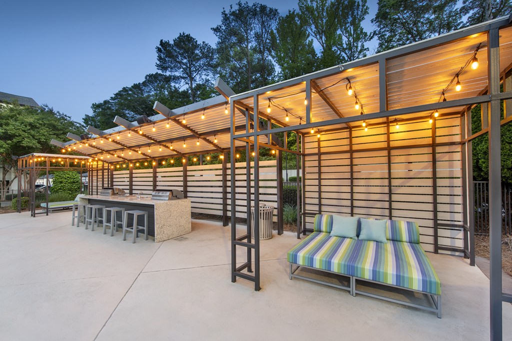 A patio with a striped couch and a table with a bench.