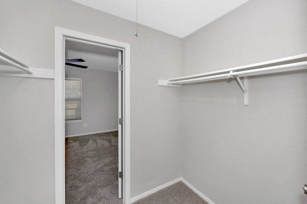 A white door is open to a room with a carpeted floor.