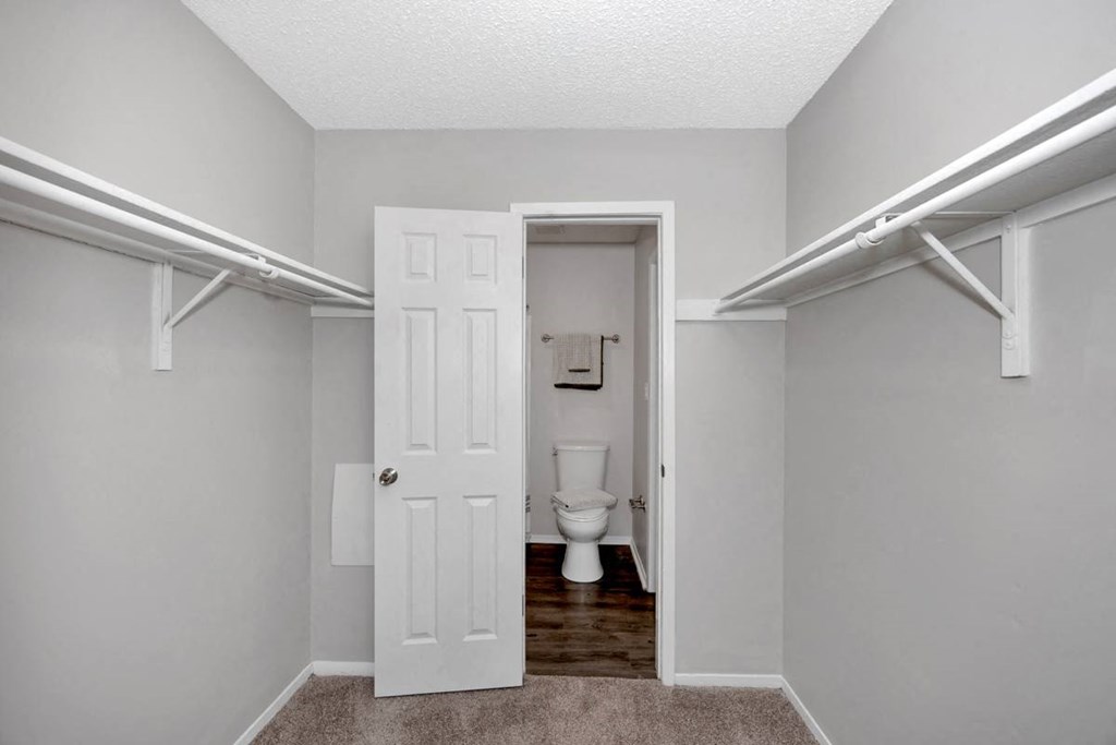 A white door is open to a bathroom with a toilet.