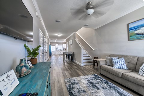 A living room with a blue couch and a rug.