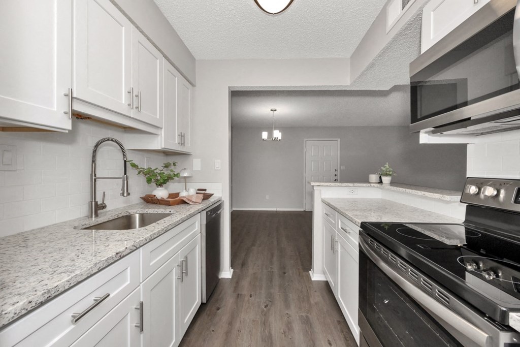 A kitchen with white cabinets and a black stove top oven.