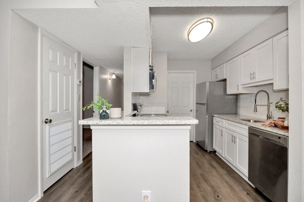 A kitchen with white cabinets and a white island.