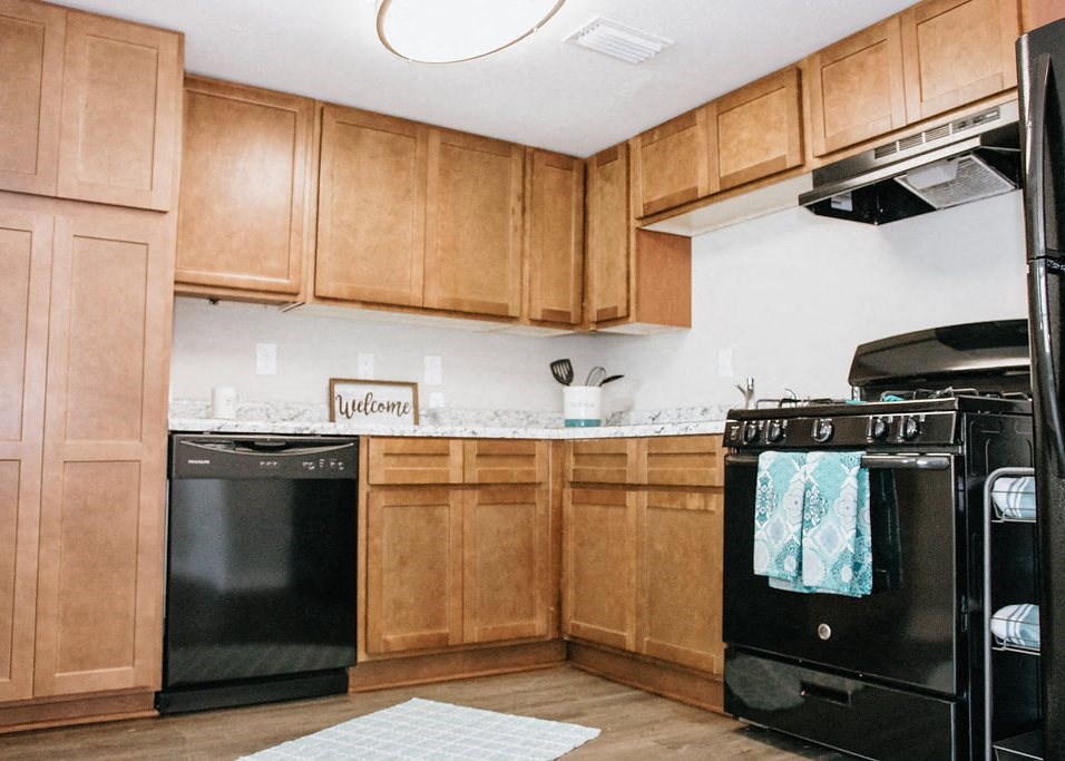 a kitchen with black appliances and wooden cabinets