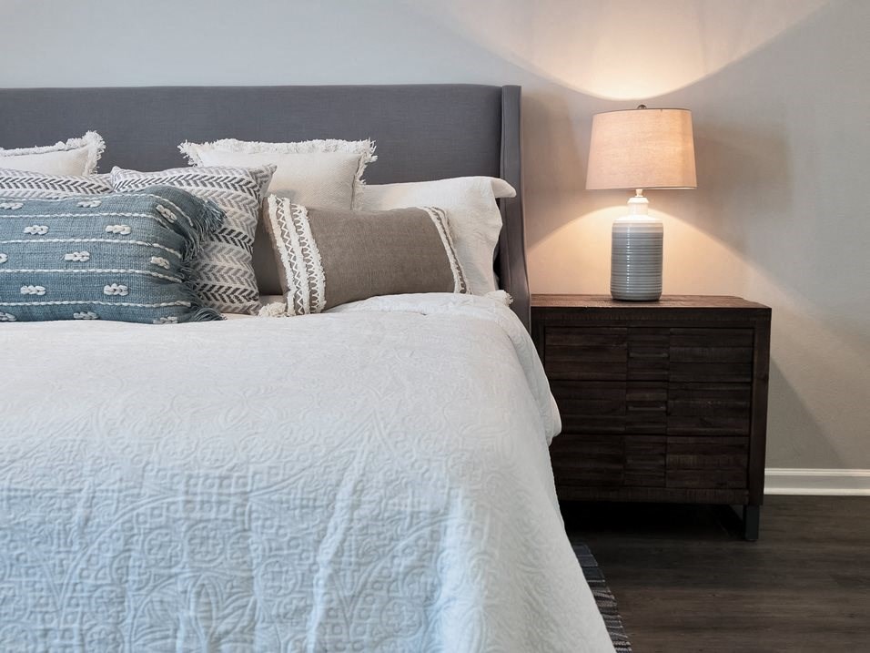 a bedroom with a bed and a night stand with a lamp