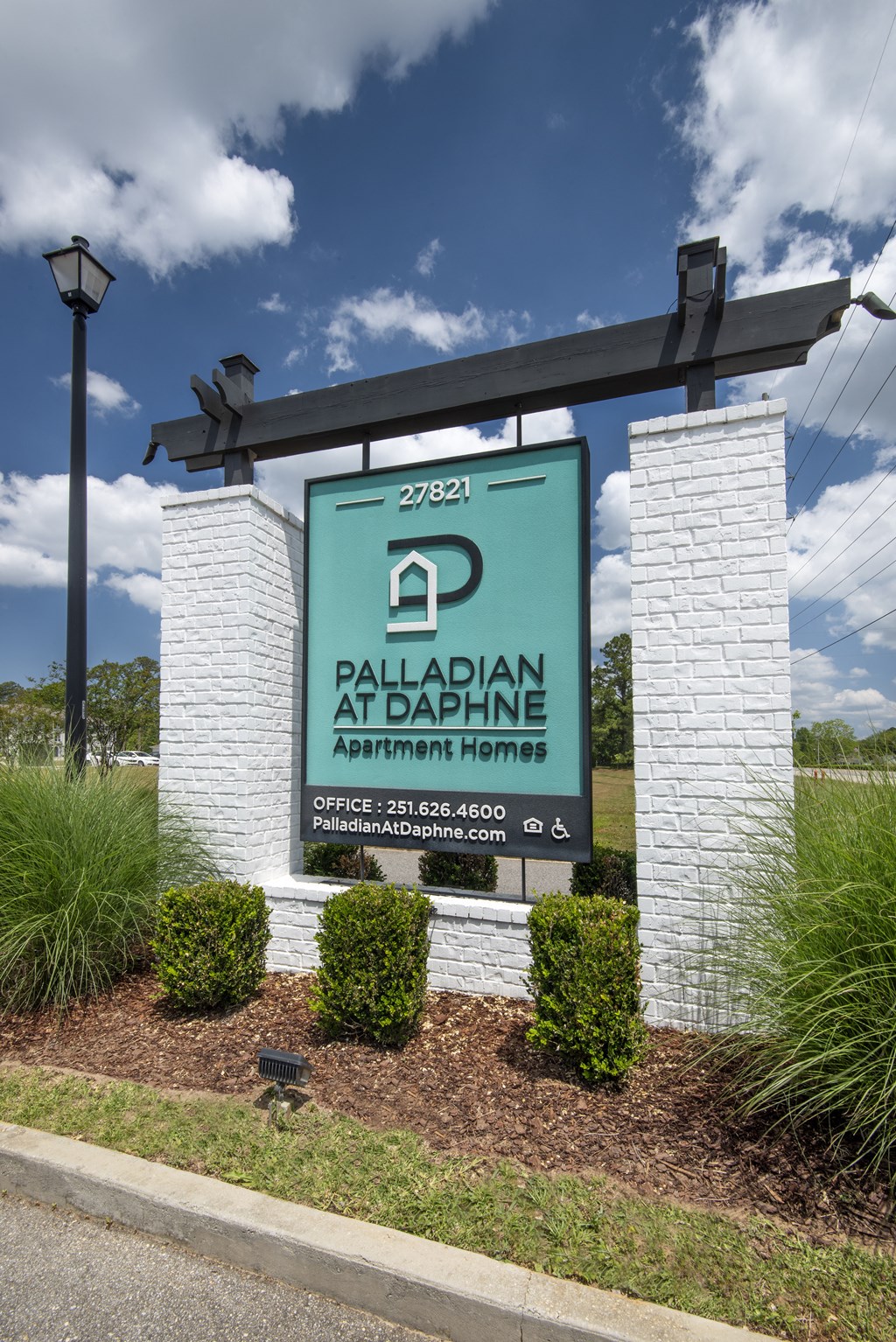 a sign for the palladian at bailey apartments on the side of a road