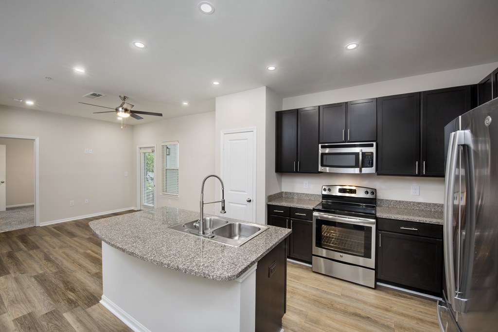 A kitchen with black cabinets and stainless steel appliances.