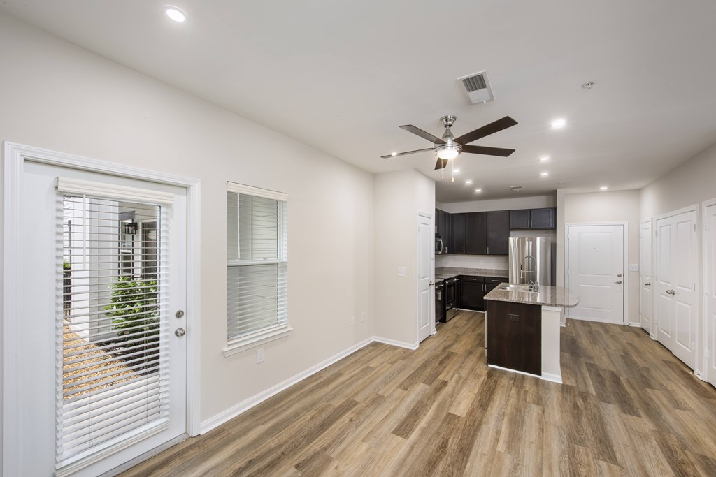 A spacious room with wooden flooring and a ceiling fan.
