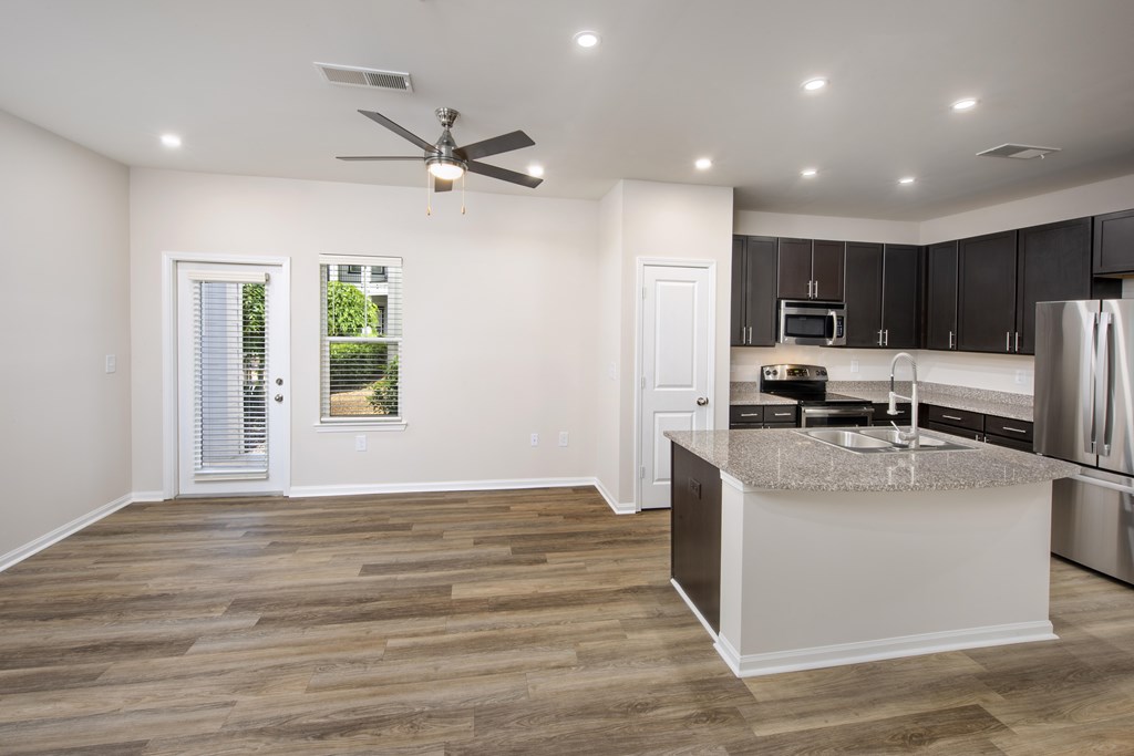 A kitchen with a large island and a ceiling fan.