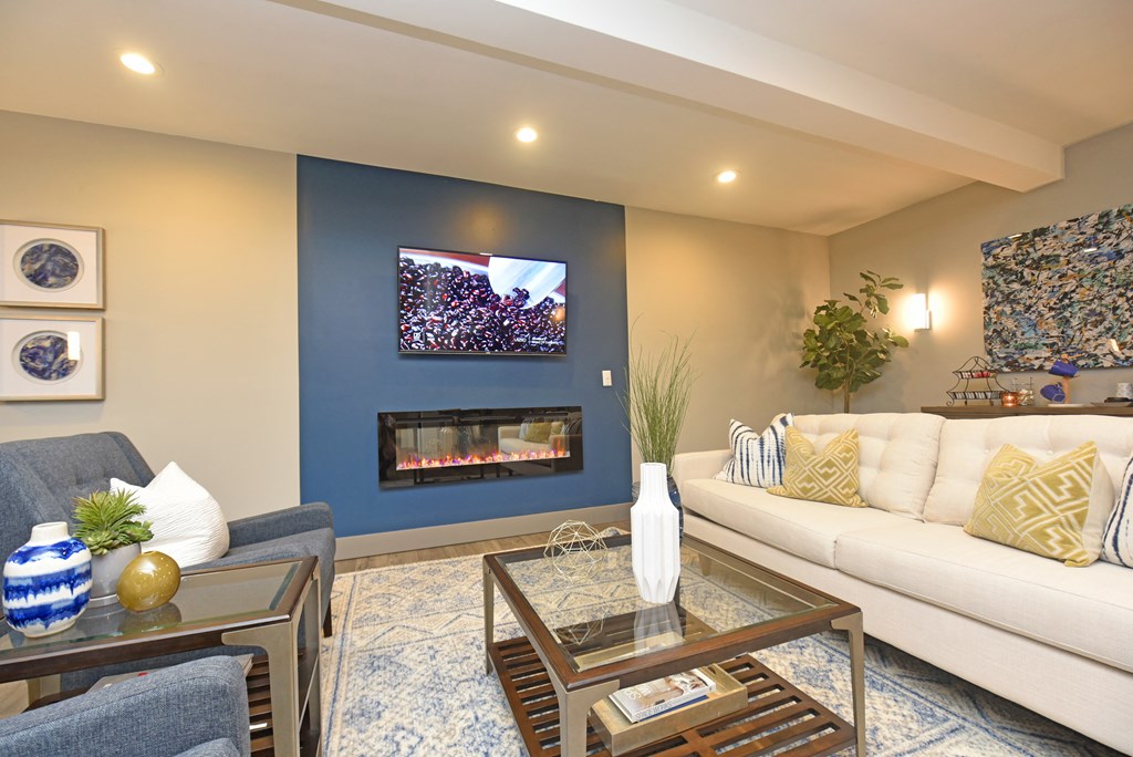 a living room with a blue accent wall and a fireplace